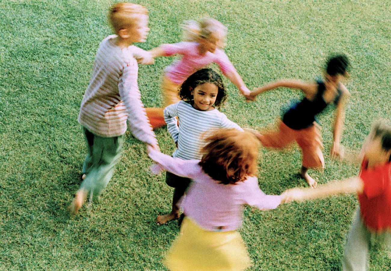 Kinder spielen im Kreis auf der Wiese